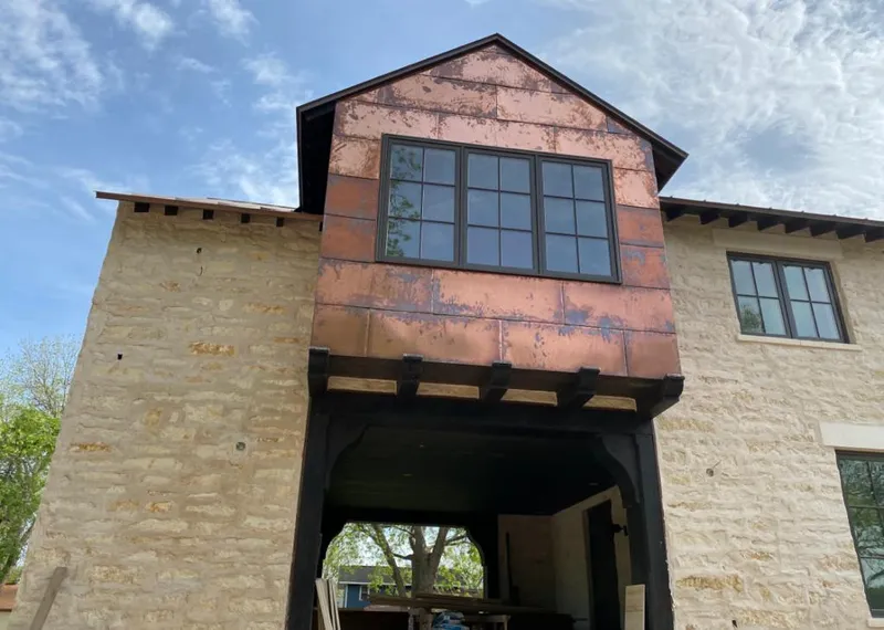 Copper metal panel facade on a stone building for Skylight Installation in River Falls