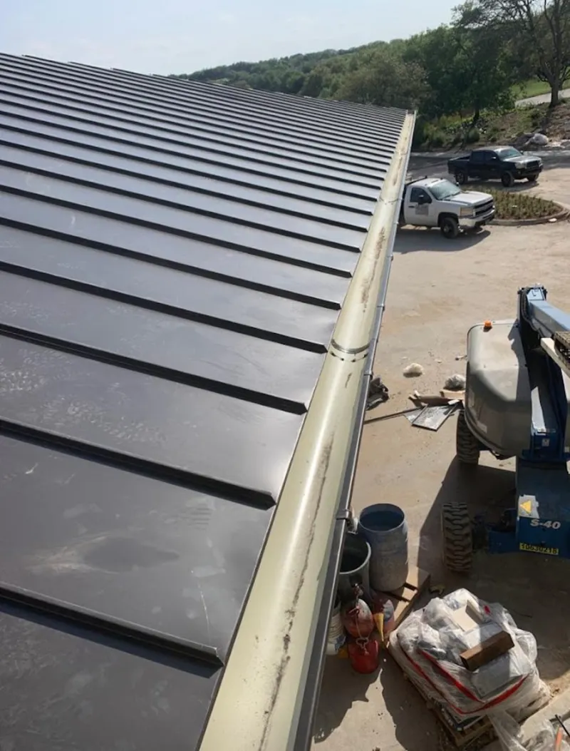Standing seam panel and gutter detail on a metal roofing jobsite in River Falls